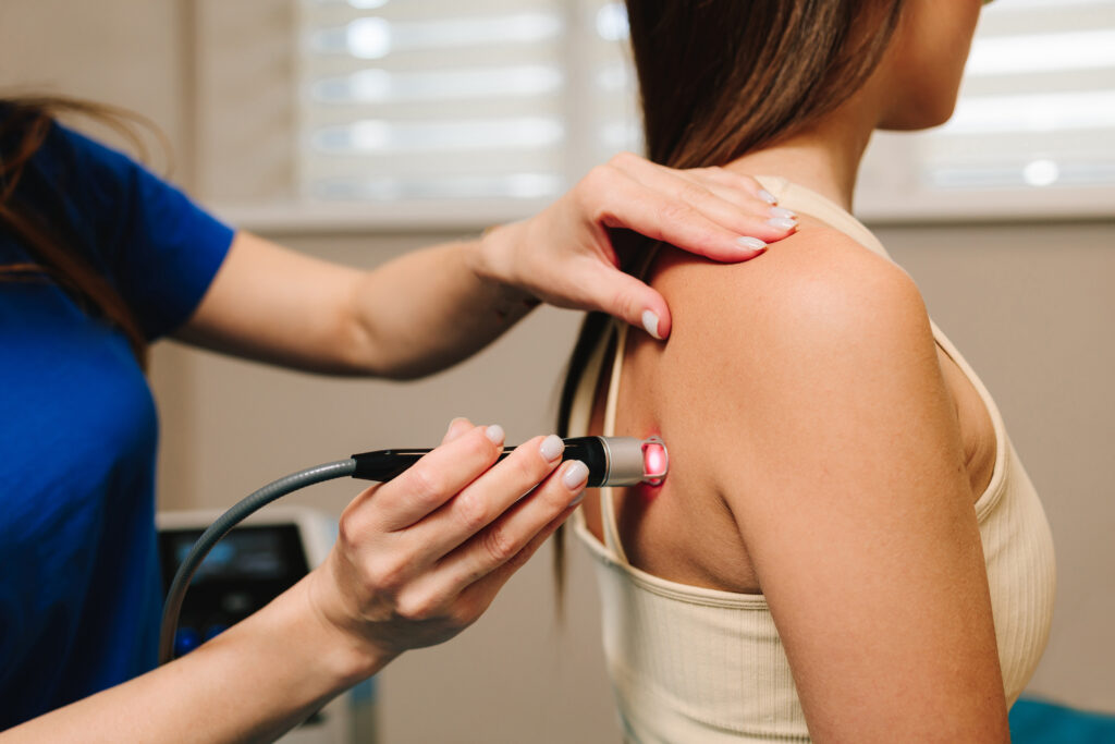 Chiropractic practitioner applying targeted therapy to a patient's shoulder